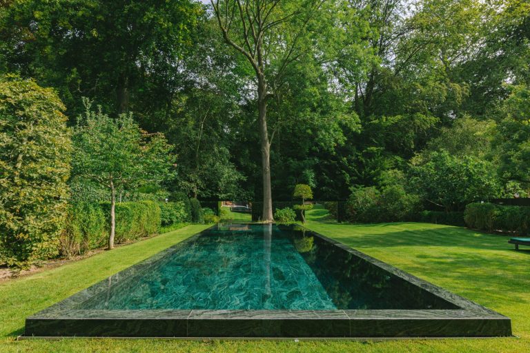 Home Zwembadspecialist toont plannen voor de bouw van een exclusief zwembad in een privétuin met aandacht voor design en maatwerk